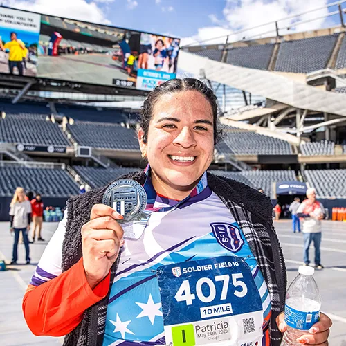 female with medal at finish line