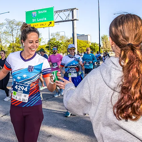 volunteer handing runner water